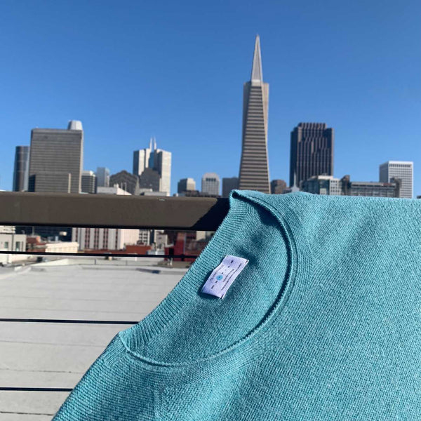 An all-season boat neck sweater against a city view