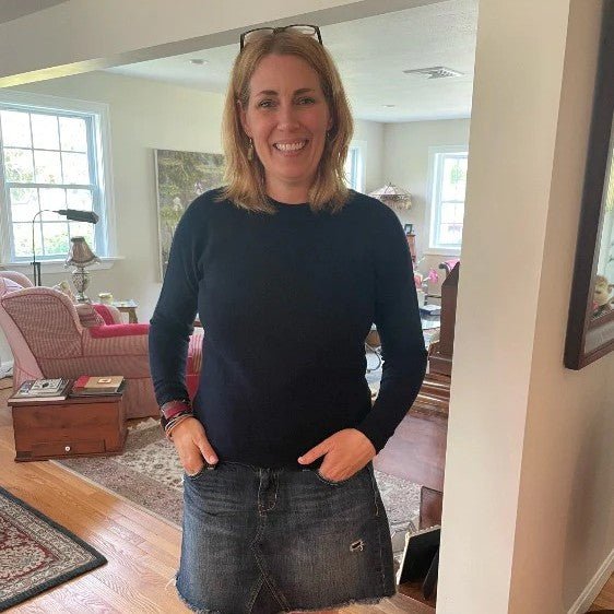 A woman in a plain dark long-sleeve knit, the minimalist wardrobe in practice